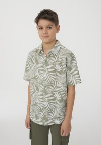 Camicia a maniche corte in lino verde chiaro, con un motivo botanico bianco, una chiusura frontale con bottoni e un colletto classico.