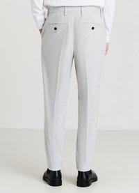 Hellgraue maßgeschneiderte Hosen mit strukturiertem Finish, ausgestattet mit Gesäßtaschen und schwarzen Knopfverschlüssen. Gerader Schnitt und Gürtelschlaufen.