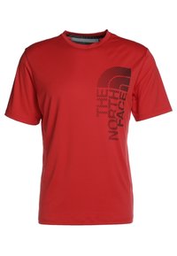 Camiseta roja de manga corta hecha de tejido suave, que presenta un diseño gráfico negro de "THE NORTH FACE" en la parte frontal.