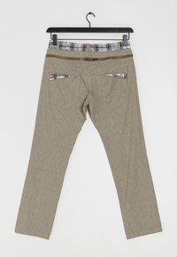 Beiga byxor med en subtil textur, med en rutmönstrad midja och blixtlåsdetalj. Två bakfickor med rutmönstrade accenter. Rakt ben.