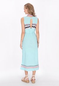 O rochie fără mâneci, de culoare albastru deschis, cu un decolteu în formă de cheie la spate, dintr-un material texturat, având un tiv cu un model ce include dungi roz și negre.