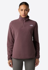 Fleece pullover in mauve, met een kraag met halve rits, lange mouwen en een logo-accent op de borst. Soepele textuur, ontspannen pasvorm.