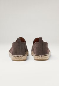 Brune ruskinds-espadriller med sål af jute-reb, rund ryg og bageste trækstrop for nem påtagning. Har en glat tekstur og et enkelt design.