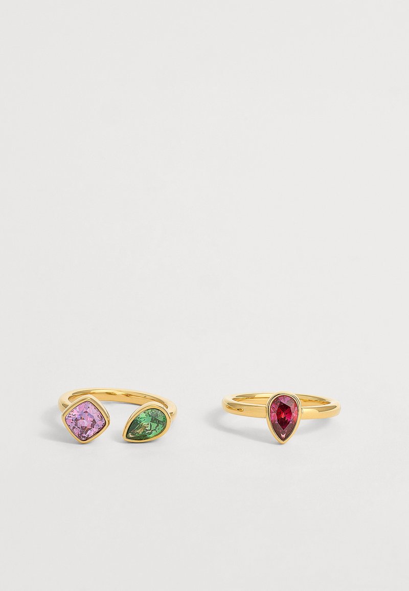 Deux bagues en or avec des pierres précieuses colorées : une avec des pierres roses et vertes, l'autre avec une seule pierre rouge en forme de goutte.