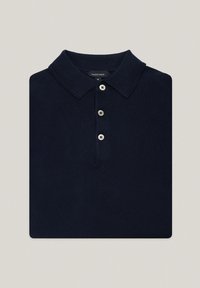 Granatowa koszulka polo wykonana z dzianiny, z klasycznym kołnierzykiem, trzydziestoma guzikami i subtelną fakturą. Etykieta widoczna wewnątrz kołnierzyka.