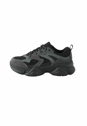 Baskets de sport noires avec une tige en mesh, des superpositions synthétiques grises, une semelle épaisse et une finition texturée, dotées d'une languette à l'arrière.