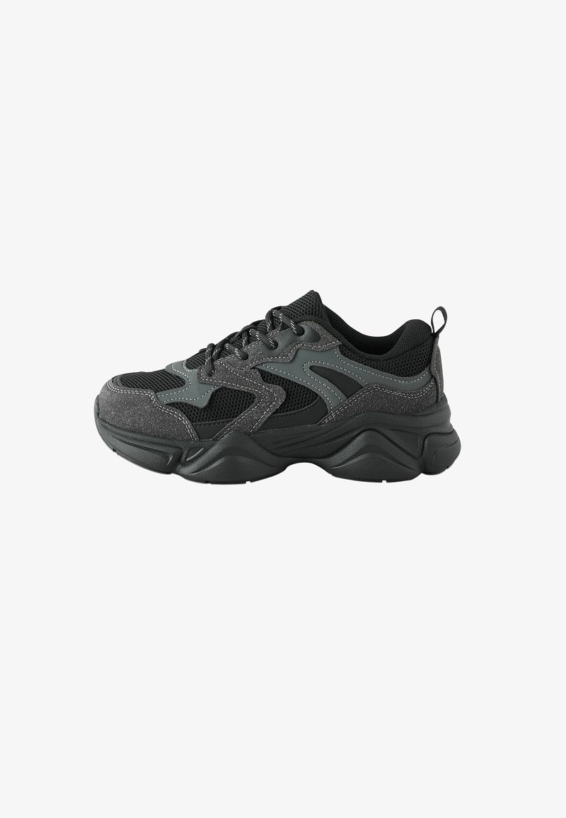 Baskets de sport noires avec une tige en mesh, des superpositions synthétiques grises, une semelle épaisse et une finition texturée, dotées d'une languette à l'arrière.