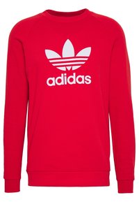 Červená mikina vyrobená z bavlněné směsi, s bílým logem Adidas a třemi bílými pruhy, s žebrovanými manžetami a lemem.