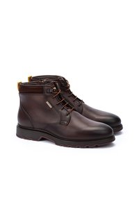 Brown leather ankle boots with a textured finish, laces, and a yellow accent at the heel. Features a sturdy rubber sole for grip.