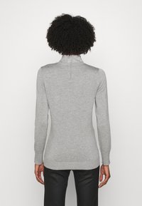 Jasnoszary sweter z długimi rękawami i kołnierzem na zamek błyskawiczny ozdobiony dekoracyjnymi ćwiekami. Ściągacze na mankietach i dole z dopasowanym krojem.