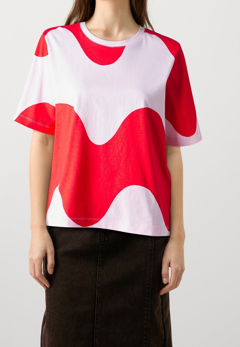 Camiseta de manga corta con un audaz patrón abstracto de olas en rojo y blanco. Confeccionada en tejido ligero, cuenta con un escote redondo y un corte relajado.