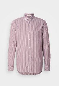 Chemise à manches longues boutonnée avec des rayures verticales rouges et blanches, poche poitrine avec petit logo brodé et col boutonné.