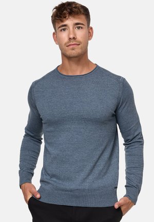 Suéter azul de mangas largas en un tejido suave, con un escote redondo, puños y dobladillo acanalados, con una textura sutil y un diseño ligero.