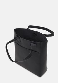 Czarna skórzana torba na ramię o teksturowej powierzchni, z dwoma uchwytami i wewnętrzną kieszenią. Posiada zapięcie na magnes oraz minimalistyczny design.