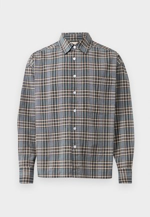 Cămașă cu mânecă lungă, cu nasturi, cu un model în carouri albastre, maronii și bej, având un buzunar pe piept, pe un fundal deschis.