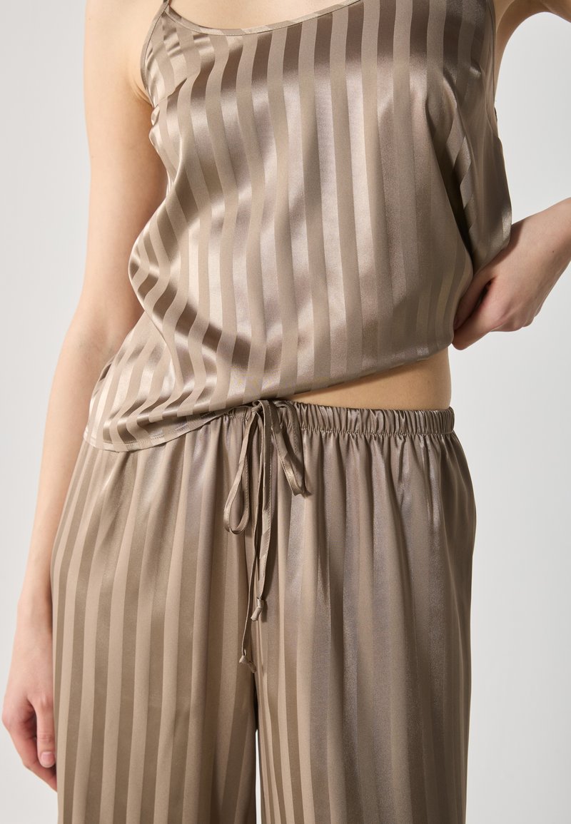 Ensemble de loungewear en mélange de soie de couleur brun clair avec des rayures verticales, comprenant un haut cami à coupe ample et un pantalon à cordon de serrage avec une taille élastique.