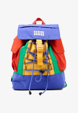Kolorowy plecak z niebieską klapką, czerwonymi bocznymi kieszeniami, zielonymi panelami, żółtą przednią częścią, niebieskim sznurkiem do zapinania oraz białym napisem na klapce.