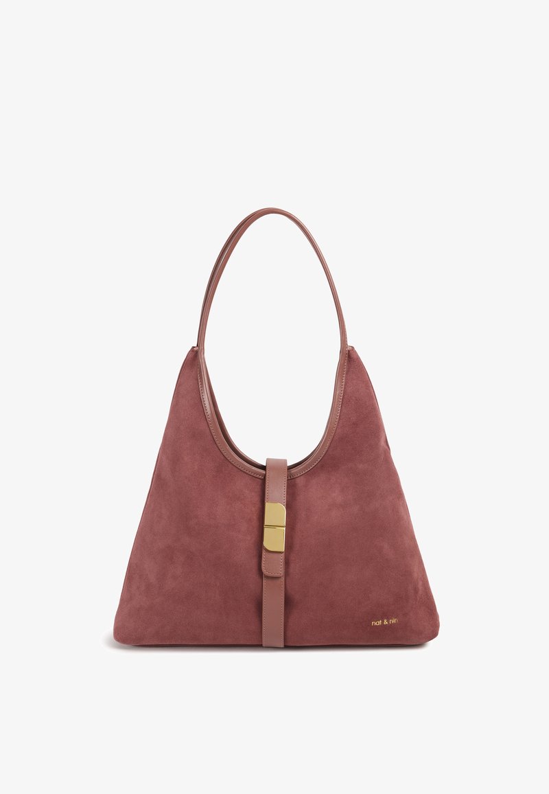 Sac à bandoulière en daim rose poussiéreux avec une sangle en cuir lisse et des éléments dorés. Il présente un dessus arrondi et une fermeture centrale à languette.