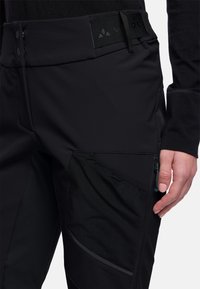 Zwarte outdoorbroeken van gladde stof, met mesh accenten en een ritszak. Platte tailleband met twee knoopsluitingen.