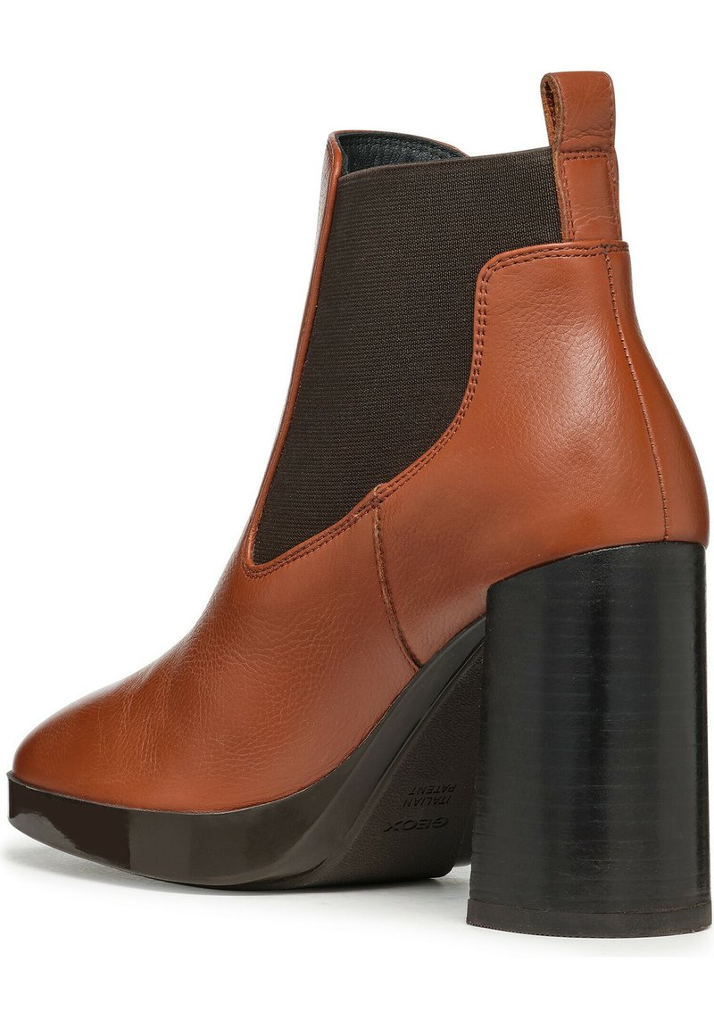 Bottine en cuir marron avec un large talon noir, des panneaux latéraux élastiques, une pointe arrondie et une finition texturée.