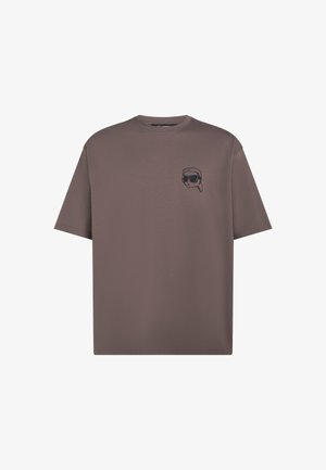 Braunes T-Shirt mit kurzen Ärmeln und Rundhalsausschnitt mit kleinem schwarzem, besticktem Gesicht mit Sonnenbrille und Bandana auf der linken Brust.