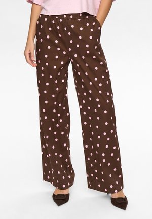 Brune vidde bukser med lyserøde polkaprikker, der har elastisk talje og lommer. Stoffet virker glat med en diskret glans.