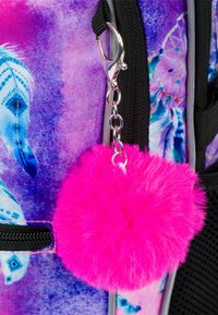 Portachiavi a pompon di pelliccia rosa con clip argentata, attaccato a uno zaino multicolore con un design viola e blu.