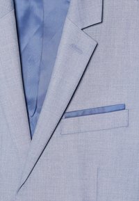 Hellblaues Blazer aus strukturiertem Stoff, mit Revers, und einer Brusttasche, die mit einem gestreiften blauen Futter ausgestattet ist. Schlichtes Design und maßgeschneiderter Look.