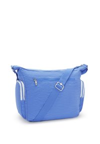 Blå tygaxelväska med texturerad yta, justerbar rem, framficka med dragkedja och vita detaljer på sidofickorna.