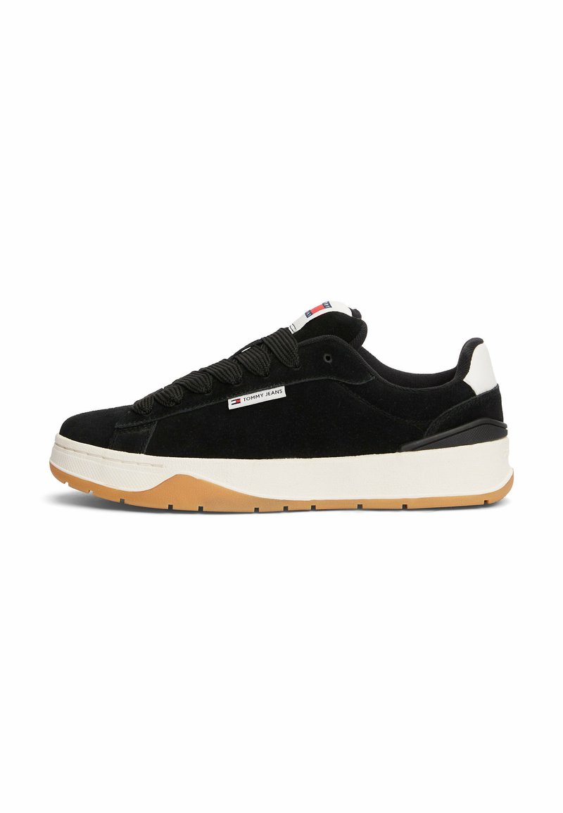 Zapatillas de vuelta de cuero negro con talón y suela blanca, suela de goma, cordones negros gruesos y etiqueta con el logotipo de "Tommy Jeans" en el lateral.