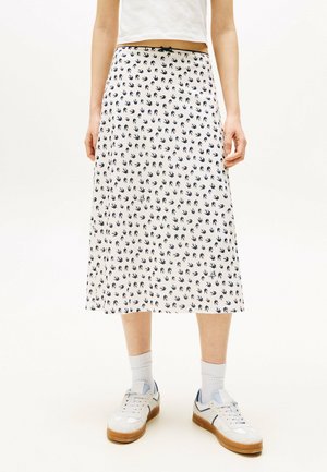 Gonna midi bianca con stampa di uccelli blu navy, caratterizzata da un cinturino aderente e un tessuto leggero, abbinata a scarpe da ginnastica bianche e calzini a coste.
