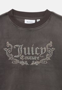 Fekete pulóver kerek nyakkal, strasszokkal díszítve, amelyek a "Juicy Couture" feliratot alkotják egy díszes mintában. Puha tapintású, alkalmi fazon.