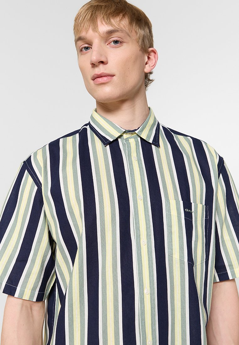 Kurzarm-Hemd mit Kragen in marineblau, weiß und grünen senkrechten Streifen; verfügt über eine linke Brusttasche mit Logodetail. Baumwollmischgewebe.
