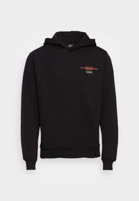 Felpa nera in tessuto morbido con tasca a marsupio anteriore. Presenta del testo rosso minimale sul petto, polsini e orlo a coste per una vestibilità aderente.