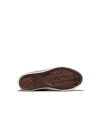 Mustvalge Converse All Star tossu tallal pruun tekstuuriga kummipõhi ja keskel nähtav logo.