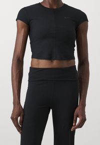 Svart kortärmad träningströja med rundad halsringning och subtilt strukturerat mönster. Har liten svart Nike-logotyp på bröstet.