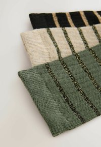 Three knitted headbands in black, cream, and olive green, featuring thin vertical stripes of metallic threads for texture and detail.
