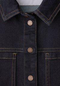 Veste en jean bleu foncé à l'avant avec des boutons en cuivre étiquetés "BY STREET ONE DENIM" et des surpiqûres contrastantes orange.
