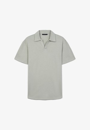 Polo shirt verde chiaro a maniche corte con colletto, caratterizzato da una texture sottile e una vestibilità rilassata. Nessun motivo o accentuazione visibile.