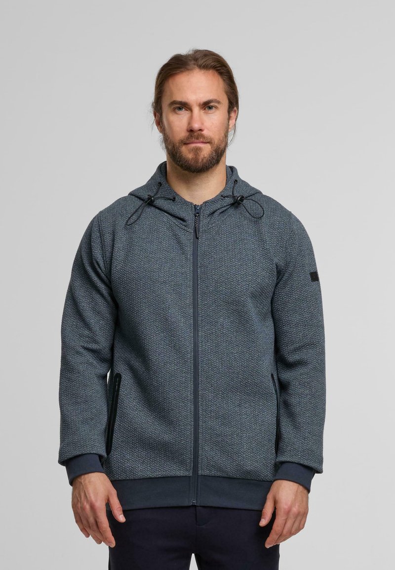 Kapuzensweatjacke aus strukturiertem dunkelblauen Stoff, mit Reißverschlusstaschen an den Seiten und verstellbaren Kordeln an der Kapuze.
