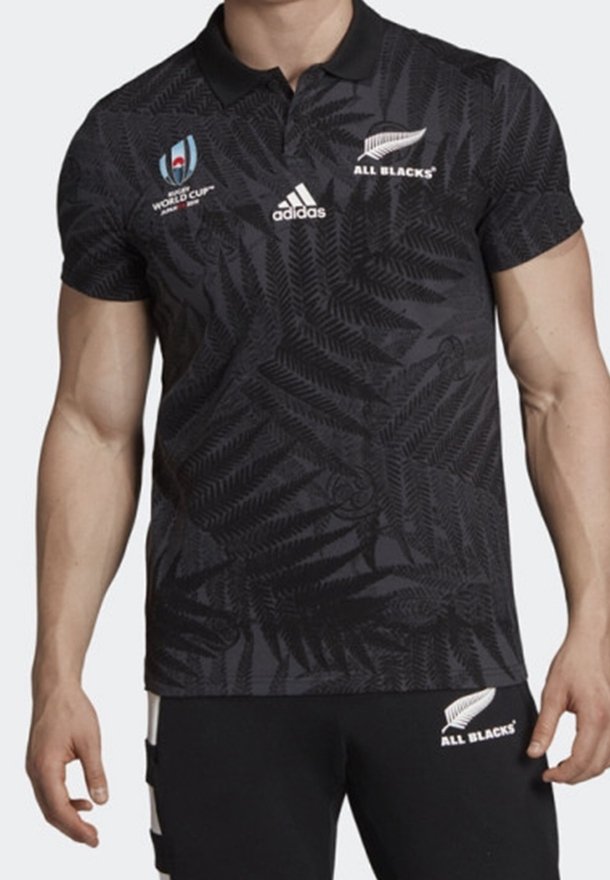 Svart pikétröja med fjädrande mönster, som har VM- och All Blacks-logotyper, adidas-märke och klassisk krage. Kortärmad.