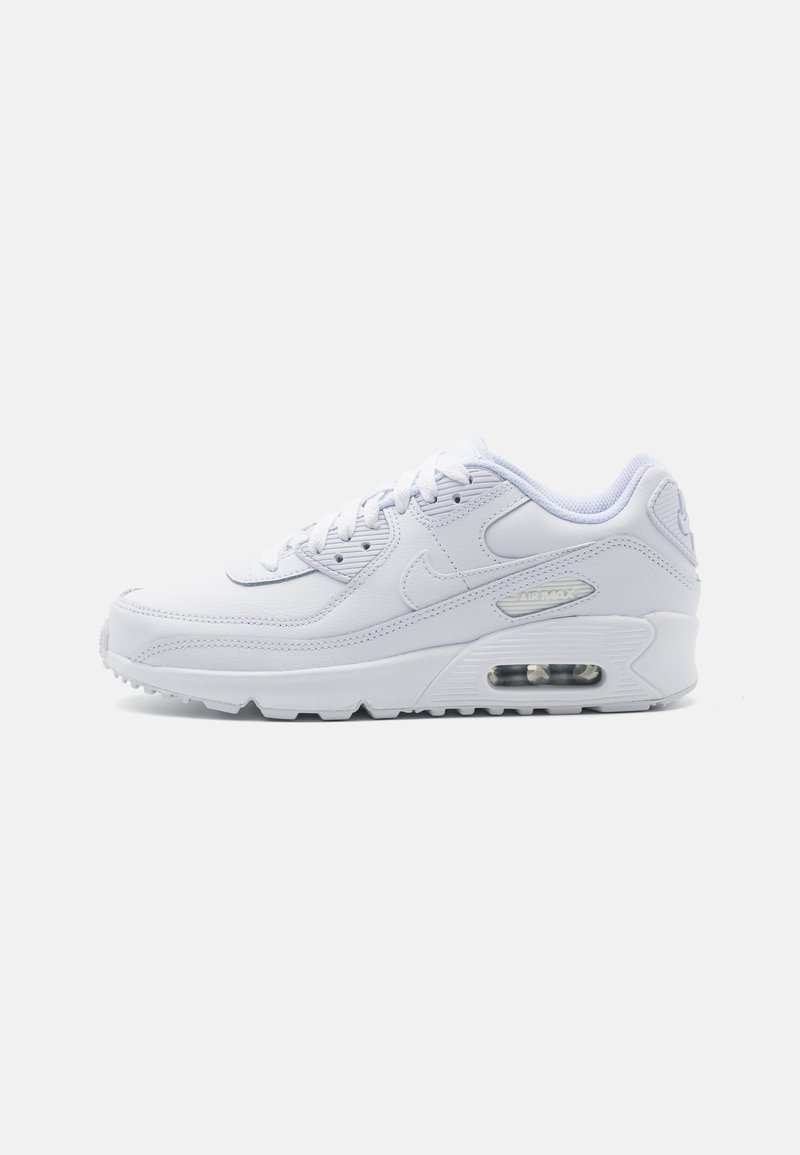 Chaussure de sport blanche avec une tige en cuir lisse, un design à lacets et une unité de coussin d'air visible. Présente une semelle extérieure en caoutchouc avec une bonne traction.