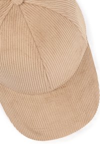 Lichtbeige corduroy pet met een ronde kroon, geaccentueerde stiksels en een gestructureerd oppervlak. De vizier is licht gebogen en de stof is ribbelig.