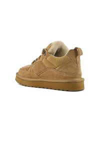 Brown suede sneakers with a textured upper, a padded collar, and a chunky gum sole. Features lacing loops and a soft inner lining.