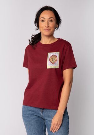 Bordeaux katoenen t-shirt met korte mouwen, voorzien van een geprinte pizzagrafiek in een rechthoekig ontwerp aan de voorkant. Blauwe jeans eronder gedragen.