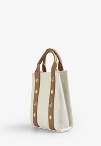Borsa a tracolla in tela avorio chiaro con manici in pelle marrone. Presenta dettagli in argento e crema e un design strutturato.