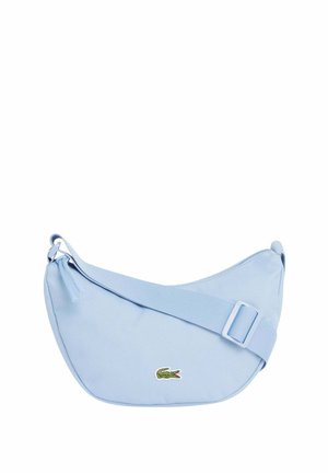 Lichtblauwe kruislingse tas in halve maanvorm met verstelbare riem en klein groen krokodillenlogo aan de voorkant.