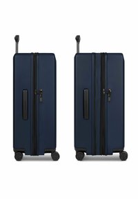 Maleta rígida de color azul marino con doble cremallera, asa lateral y cuatro ruedas. Cuenta con una superficie texturizada y un sistema de cierre integrado.