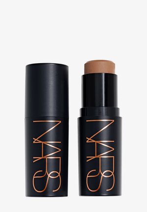 Svart NARS sminkestift med lokk av, som viser en medium beige foundation- eller concealer-stift inni.