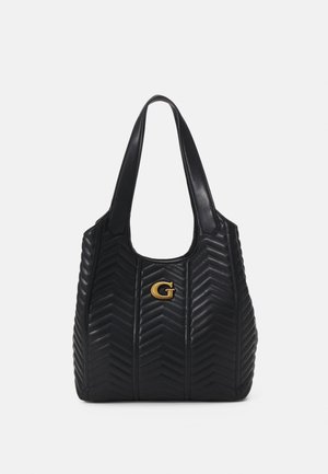 Sort quiltet skuldertaske med chevron-mønster og gyldent bogstav G-logo på fronten, med to brede håndtag.